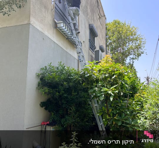 אדם על סולם מתקין תריסים על קיר חיצוני